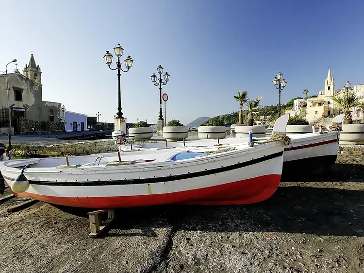 Hafen von Lipari mit Fischerboot und Promenade.
