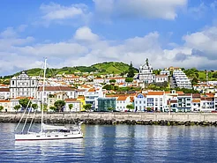 Blick auf Horta auf Faial-Küste, Hafenbecken und bunte Häuser am Ufer.