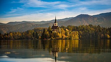 Inselkirche auf dem Bleder See, Herbstfarben, Bergkulisse und Spiegelung.