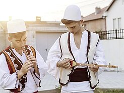 Zwei Männer in traditioneller albanischer Tracht, Westen und bestickte Hemden.