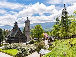 Norwegische Stabkirche Wang, umgeben von Gartenanlage.
